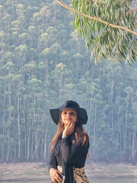 Fazna in a wide hat among tall trees